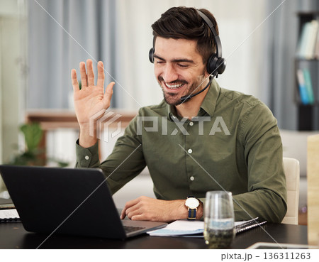 Man, remote work and virtual assistant with headphones at laptop for video call, voip communication and telemarketing. Consultant wave at computer with microphone for customer support at home office 136311263