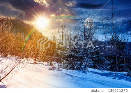 winter solstice landscape. day and night time change concept. deciduous forest on snow covered hill with sun and moon at twilight. beautiful scenery under blue sky. duality and transition template winter solstice landscape. day and night time change concept. deciduous forest on snow covered hill with sun and moon at twilight. beautiful scenery under blue sky. duality and transition template 136311276