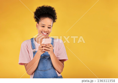Smile, typing and woman with phone in studio, texting or social media post with mockup on yellow background. Networking, chat online and happy model with cellphone mobile app, reading meme or email Smile, typing and woman with phone in studio, texting or social media post with mockup on yellow background. Networking, chat online and happy model with cellphone mobile app, reading meme or email 136311358