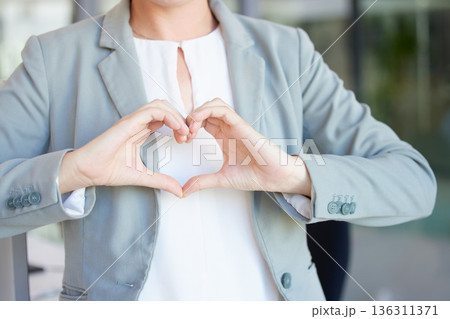 Hands, heart and business woman with love emoji for care, kindness and like review in office. Closeup of female worker with finger shape for thank you, trust and sign of hope, support icon and peace Hands, heart and business woman with love emoji for care, kindness and like review in office. Closeup of female worker with finger shape for thank you, trust and sign of hope, support icon and peace 136311371