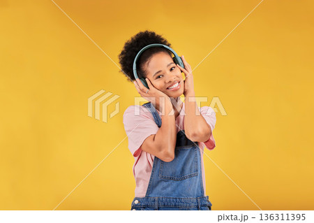 Music, headphones and happy black woman in portrait listening in studio isolated on a yellow background mockup space. Face, smile and person hearing radio, podcast or sound for jazz, hip hop or audio Music, headphones and happy black woman in portrait listening in studio isolated on a yellow background mockup space. Face, smile and person hearing radio, podcast or sound for jazz, hip hop or audio 136311395