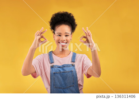 Portrait, perfect and hand gesture with an excited black woman in studio on a yellow background. Smile, wow and okay with a happy young female person showing a sign of support, feedback or review Portrait, perfect and hand gesture with an excited black woman in studio on a yellow background. Smile, wow and okay with a happy young female person showing a sign of support, feedback or review 136311406
