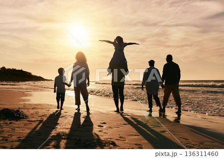 Silhouette, family is walking on beach and back view with ocean waves, sunset and bonding in nature. Generations, people outdoor and tropical holiday, freedom and travel with trust and love in Mexico 136311460