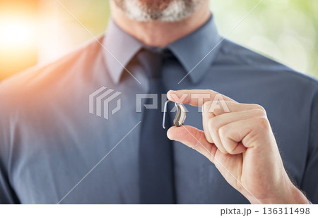 Hearing aid, hands and business man with disability for communication support, listening and medical innovation. Closeup of deaf worker with audiology implant to help sound waves, amplifier or volume 136311498