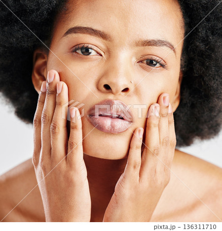 Beauty, skin care and portrait of a black woman with dermatology, cosmetics or natural makeup. Closeup and face of serious African female model in studio for facial glow, self love and soft touch Beauty, skin care and portrait of a black woman with dermatology, cosmetics or natural makeup. Closeup and face of serious African female model in studio for facial glow, self love and soft touch 136311710
