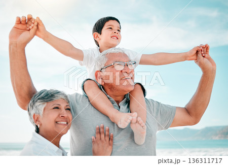 Beach, family and child on grandfather shoulder with grandmother outdoor, love and bond on holiday. Summer, happiness and people in nature, tropical vacation in Mexico with old man, woman and boy kid 136311717