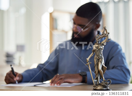 Lawyer, office and man at desk with statue of justice, contract or documents for court schedule. Consultant, law firm attorney or judge with signature paperwork for legal agreement or deal in Africa. Lawyer, office and man at desk with statue of justice, contract or documents for court schedule. Consultant, law firm attorney or judge with signature paperwork for legal agreement or deal in Africa. 136311831