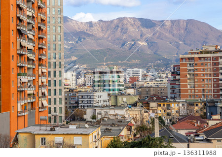 Residential apartment buildings and dense urban housing with mountains in background during daylight in capital city Tirana, Albania Residential apartment buildings and dense urban housing with mountains in background during daylight in capital city Tirana, Albania 136311988