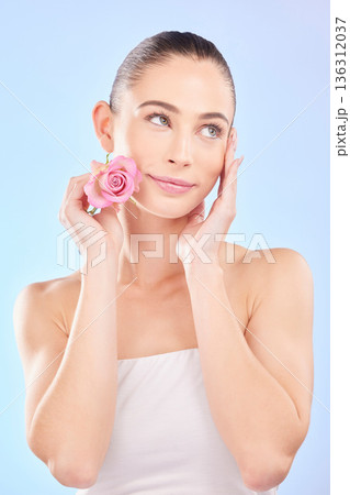 Woman, beauty and rose for skincare in studio, eco plant cosmetics and natural aesthetic on blue background. Face, female model and thinking of pink flowers, sustainable shine and floral dermatology Woman, beauty and rose for skincare in studio, eco plant cosmetics and natural aesthetic on blue background. Face, female model and thinking of pink flowers, sustainable shine and floral dermatology 136312037