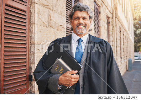 Portrait, judge or lawyer in city with legal books, constitution or research on policy, rules or knowledge on justice in court. Attorney, man with success or working with expert on government laws 136312047