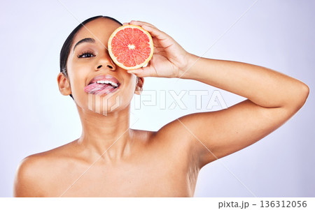 Woman, portrait and grapefruit for natural beauty, skincare or cosmetics against a studio background. Face of female person with fruit for healthy nutrition, vitamin C or diet and healthcare wellness 136312056