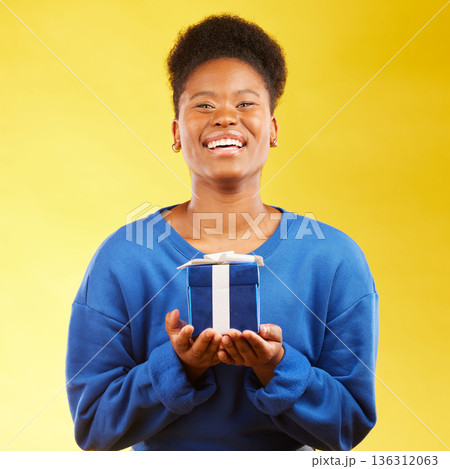 Gift, birthday and portrait of black woman with a surprise happy isolated in a yellow studio background with a present. Winning, box and excited person to celebrate, party and holiday as a winner Gift, birthday and portrait of black woman with a surprise happy isolated in a yellow studio background with a present. Winning, box and excited person to celebrate, party and holiday as a winner 136312063