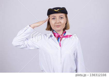 Flight attendant in aviation uniform giving military salute Flight attendant in aviation uniform giving military salute 136312108