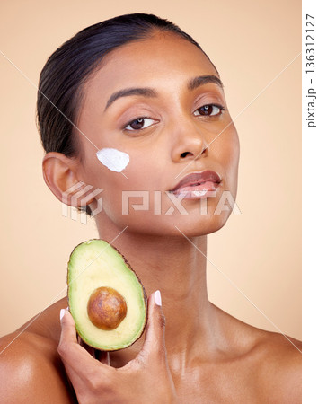 Avocado, cream and skincare with portrait of woman in studio for product, beauty and natural cosmetics. Spa, facial and lotion with face of model on brown background for vitamin c and self care Avocado, cream and skincare with portrait of woman in studio for product, beauty and natural cosmetics. Spa, facial and lotion with face of model on brown background for vitamin c and self care 136312127