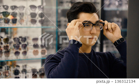 Customer checking his reflection with new glasses Customer checking his reflection with new glasses 136312134