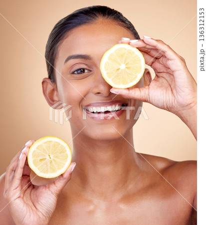 Lemon fruit, portrait and skincare of woman in studio for vitamin c benefits, eco cosmetics or nutrition. Face of indian female model, natural beauty and healthy citrus food for aesthetic dermatology Lemon fruit, portrait and skincare of woman in studio for vitamin c benefits, eco cosmetics or nutrition. Face of indian female model, natural beauty and healthy citrus food for aesthetic dermatology 136312153