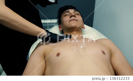 Man lying down for laser hair removal procedure 136312233
