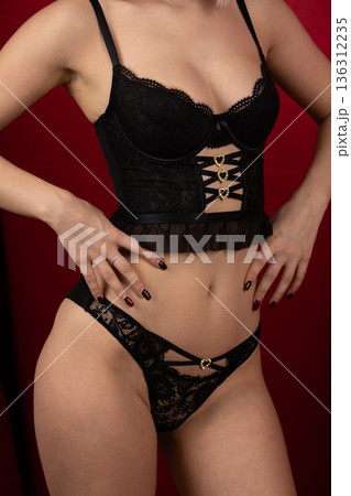 Young woman in black lace lingerie set posing provocatively 136312235