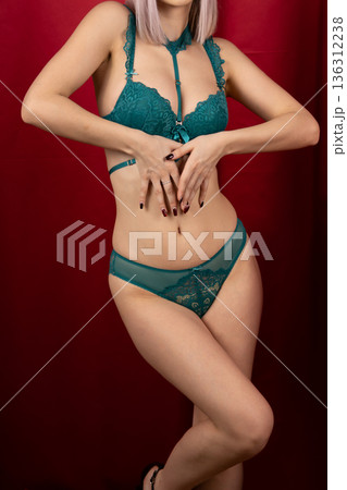 Woman adjusting her green lace bra in studio 136312238