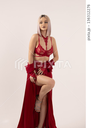 Woman wearing red silk robe over red lingerie set Woman wearing red silk robe over red lingerie set 136312276