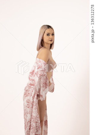 Young woman in light floral robe posing sideways 136312278