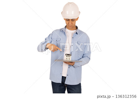 Construction worker in safety vest pointing at his equipment Construction worker in safety vest pointing at his equipment 136312356