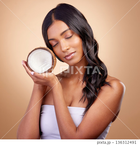 Coconut, fruit and woman with natural beauty, skincare or vegan product in cosmetics for healthy skin glow, shine or benefits. Tropical fruits, Indian model and organic oil for cosmetic cream 136312491