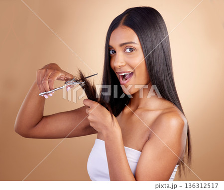 Surprise, cut and portrait of Indian woman with scissors in studio for diy, haircut or styling on brown background. Wow, face and female model with hair, treatment or styling results with beauty tool 136312517