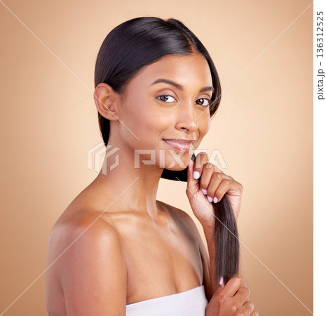 Portrait, hair care and Indian woman, with beauty, cosmetics and dermatology against a brown studio background. Face, female person or model with luxury, shine and glow with volume, growth or texture 136312525