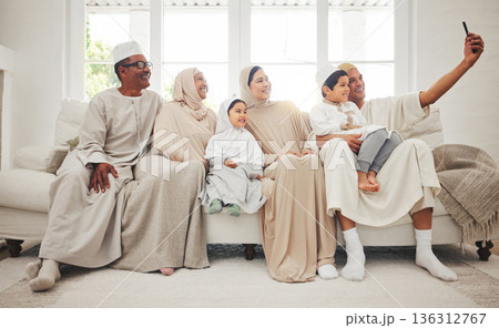 Selfie, Islam and big family on sofa with smile, grandparents and parents with kids in Arab home. Portrait of Muslim men, women in hijab and happy children, generations in sitting on couch together. Selfie, Islam and big family on sofa with smile, grandparents and parents with kids in Arab home. Portrait of Muslim men, women in hijab and happy children, generations in sitting on couch together. 136312767