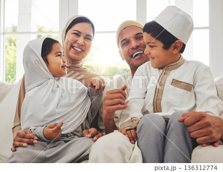 Happy family, Islam and laughing on couch for Eid with mom, dad and kids with home culture in Indonesia. Muslim man, woman in hijab and children smile, funny bonding on sofa together in living room. 136312774