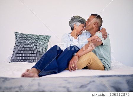 Love, kiss and senior couple on their bed in their home while relaxing, bonding and spending time together. Happy, affection and elderly man and woman in retirement resting in bedroom in their house. Love, kiss and senior couple on their bed in their home while relaxing, bonding and spending time together. Happy, affection and elderly man and woman in retirement resting in bedroom in their house. 136312873