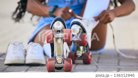 Roller skates, hands and tie shoes on the ground to start exercise, workout or training outdoor. Skating, person and tying laces to get ready for sports on street to travel, journey and fitness. Roller skates, hands and tie shoes on the ground to start exercise, workout or training outdoor. Skating, person and tying laces to get ready for sports on street to travel, journey and fitness. 136312940