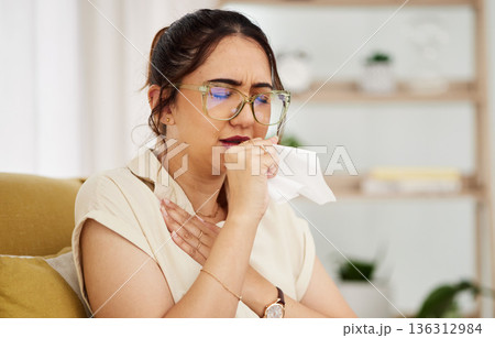 Coughing, tissue and sick woman on a sofa with cold, flu or sore throat in her home. Allergies, influenza and female with viral infection, bacteria and covid risk in a living room with tuberculosis Coughing, tissue and sick woman on a sofa with cold, flu or sore throat in her home. Allergies, influenza and female with viral infection, bacteria and covid risk in a living room with tuberculosis 136312984