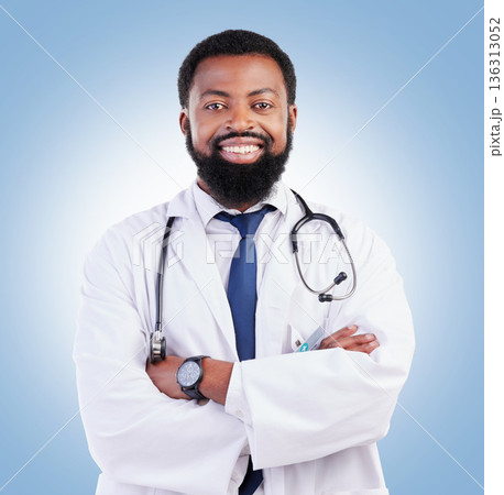 Doctor, black man and portrait with arms crossed in studio or happy medical expert or healthcare worker on blue background. African surgeon, smile and confidence in medicine or research in hospital Doctor, black man and portrait with arms crossed in studio or happy medical expert or healthcare worker on blue background. African surgeon, smile and confidence in medicine or research in hospital 136313052