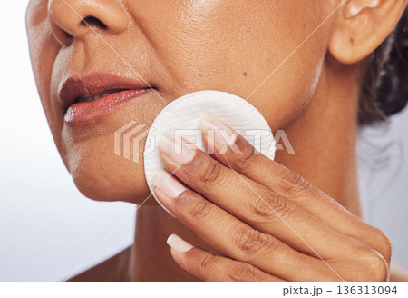 Beauty, closeup or woman with cotton pad for dermatology, wellness or facial skincare routine in studio. White background, hand or face of lady cleaning with swab for glow, cleansing or dirt removal 136313094