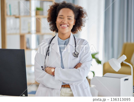 Black woman, portrait and doctor with arms crossed in hospital for medical services, advice and wellness consulting. Medicine, healthcare and happy young female therapist working with trust in clinic 136313095