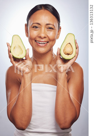 Portrait, skincare and senior woman with avocado in studio isolated on a white background. Face, natural fruit and happy model with food for vegan nutrition, healthy diet and omega 3 for anti aging. 136313132