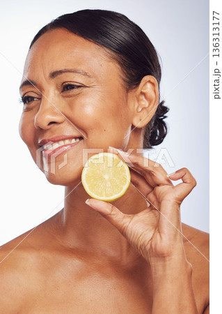 Thinking, orange and senior woman with skincare, dermatology and treatment against a white studio background. Mature female person, happy lady or model with citrus fruit, natural beauty and vitamin c Thinking, orange and senior woman with skincare, dermatology and treatment against a white studio background. Mature female person, happy lady or model with citrus fruit, natural beauty and vitamin c 136313177