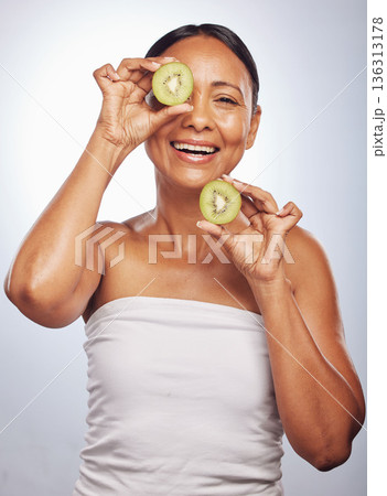 Skincare, portrait and senior woman with kiwi in studio isolated on a white background. Food, natural fruit and face of happy model with nutrition for wellness, healthy diet and anti aging for beauty Skincare, portrait and senior woman with kiwi in studio isolated on a white background. Food, natural fruit and face of happy model with nutrition for wellness, healthy diet and anti aging for beauty 136313178