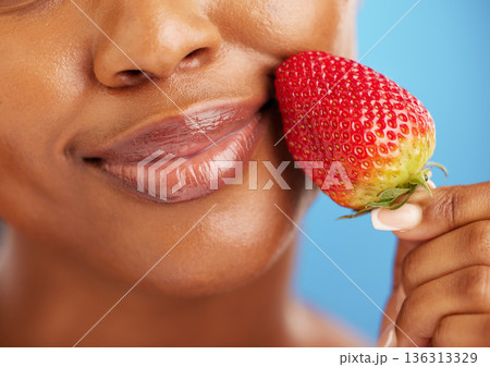Strawberry, lips and beauty woman for cosmetics, eco friendly product and color choice. Happy, mouth and skincare person or model, red fruit and dermatology or vegan makeup on studio blue background Strawberry, lips and beauty woman for cosmetics, eco friendly product and color choice. Happy, mouth and skincare person or model, red fruit and dermatology or vegan makeup on studio blue background 136313329