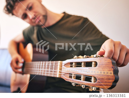 Closeup, man and tuning guitar for music, talent and creative skill of sound production in home studio. Hands, musician and singer check notes of acoustic instrument for audio, performance and artist Closeup, man and tuning guitar for music, talent and creative skill of sound production in home studio. Hands, musician and singer check notes of acoustic instrument for audio, performance and artist 136313381