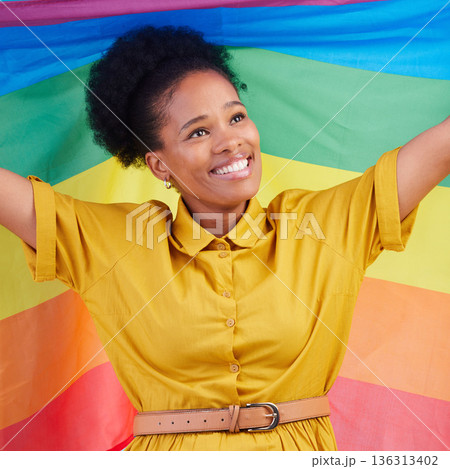 Gay, flag and happy black woman in studio for pride, rights and lgbtq lifestyle choice. Rainbow, freedom and face of lesbian African female smile, free and confident with queer sexuality or identity 136313402