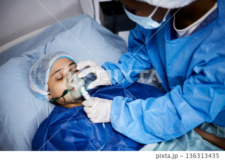Doctor, hospital bed or woman with an oxygen mask, anesthesia or operation for healthcare recovery. Medical, ventilation or sick patient with breathing equipment in coma for respiratory in emergency 136313435