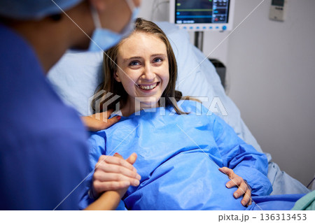 Pregnant woman, labor and hospital with holding hands, bed and support from nurse, excited smile and pain. Strong mother, midwife and helping hand in clinic for infant child, motivation and new life 136313453