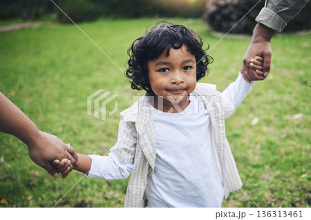 Nature, cute and boy child holding hands with his parents while walking in an outdoor park. Sweet, young and portrait of a kid with his mother and father in a green garden with love, care and support 136313461