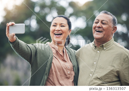 Happy senior couple, selfie and laughing for photo, picture or memory together in nature outdoors. Elderly man and woman smile for social media, online post or vlog in happiness for capture outside Happy senior couple, selfie and laughing for photo, picture or memory together in nature outdoors. Elderly man and woman smile for social media, online post or vlog in happiness for capture outside 136313507