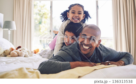 Bed, playful and portrait of a father with children for love, care or bonding in the morning. Happy, family and a young dad with kids in the bedroom of a house for quality time and playing together 136313538