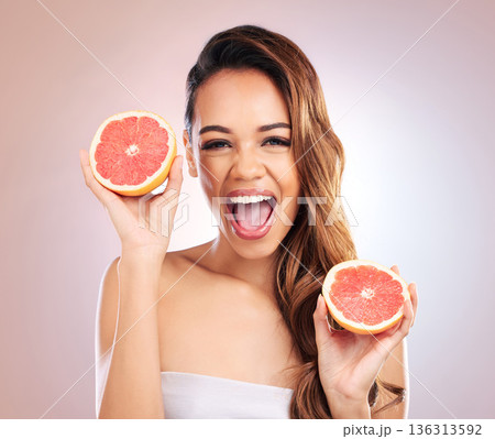 Citrus, grapefruit and portrait of woman with healthy, natural or organic beauty isolated in a brown studio background. Excited, happy and young female person with vitamin c for skincare or detox 136313592