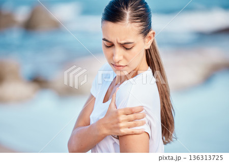 Woman, fitness and arm pain on beach from workout injury, exercise or outdoor accident. Female person with sore shoulder, joint ache or inflammation and muscle tension after exercise on ocean coast Woman, fitness and arm pain on beach from workout injury, exercise or outdoor accident. Female person with sore shoulder, joint ache or inflammation and muscle tension after exercise on ocean coast 136313725
